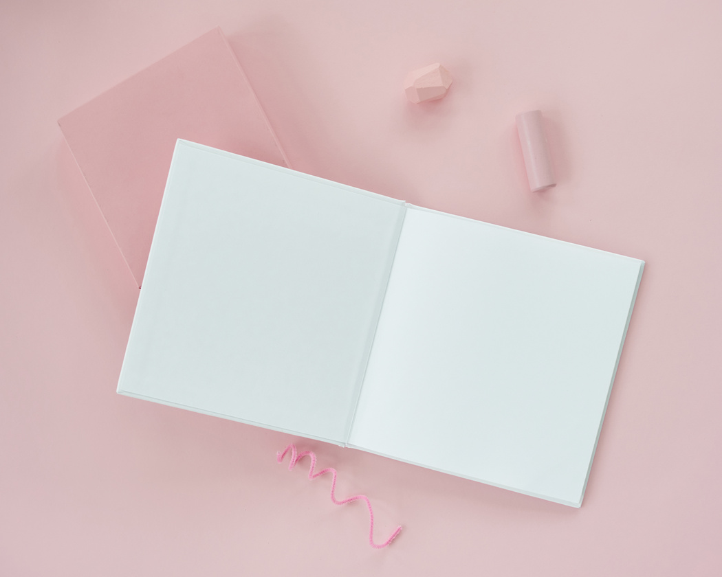 An Open Blank Book on a Pink Surface
